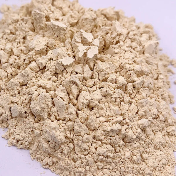 Close-up of light beige ginseng powder showing fine particles, coarse pieces, and visible soft clumping