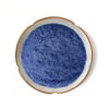 Butterfly pea flower powder in a top-view dish for botanical supplement and nutrition powder formulation