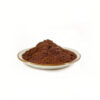 Fine brown shilajit powder in a ceramic dish for capsule and tablet formulation development