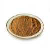 Side view of a mound of brown cinnamon extract powder in a shallow white dish on a plain background