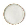 Ferulic acid powder presented as a fine white layer in a scalloped ceramic dish with a brown rim, viewed from directly above