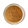 Top view of brown grape seed powder in a ceramic dish, showing the loose powdered ingredient for dry botanical blend development