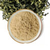 Pale tan Gynostemma pentaphyllum extract powder displayed in a ceramic dish with curled dried botanical leaves behind it