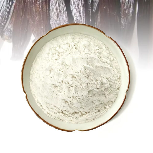Off-white vanilla powder piled in a shallow ceramic plate with dark vanilla pods arranged in the background.